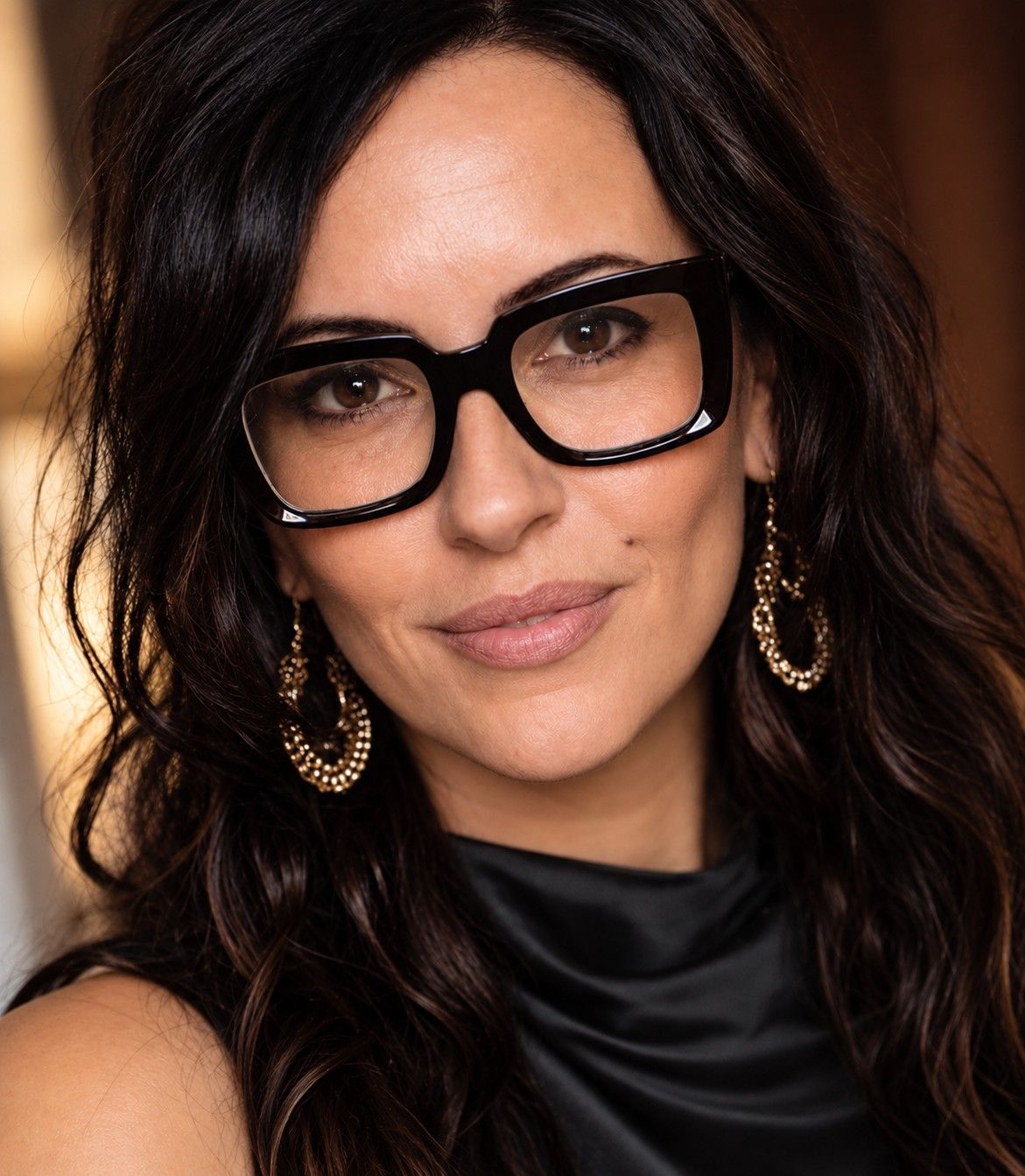 Lori Bellman wearing black glasses and looking toward the camera
