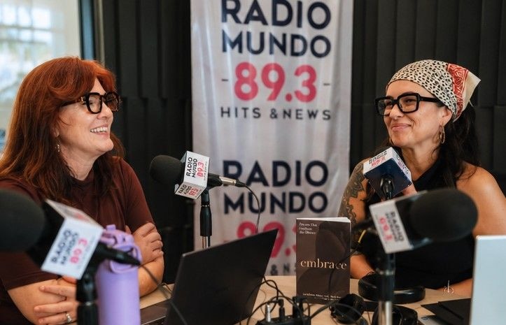 Lori Bellman and Stephanie Carmon at Radio Mundo 89.3 with microphones and an Embrace book