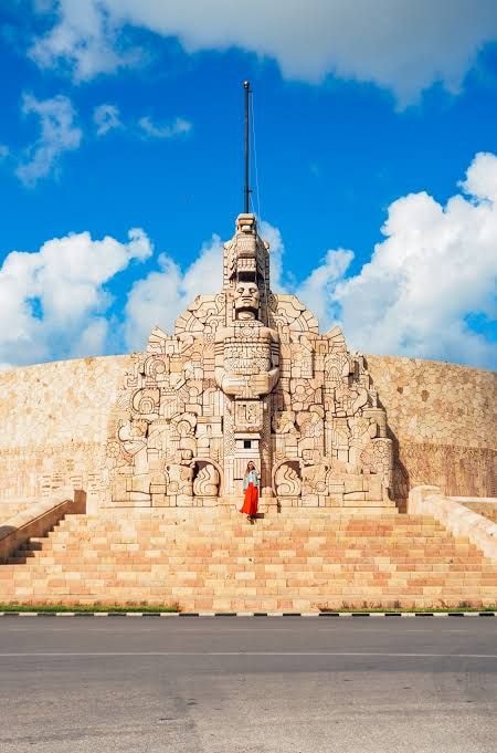 Stone Maya monument beneath a bright blue sky